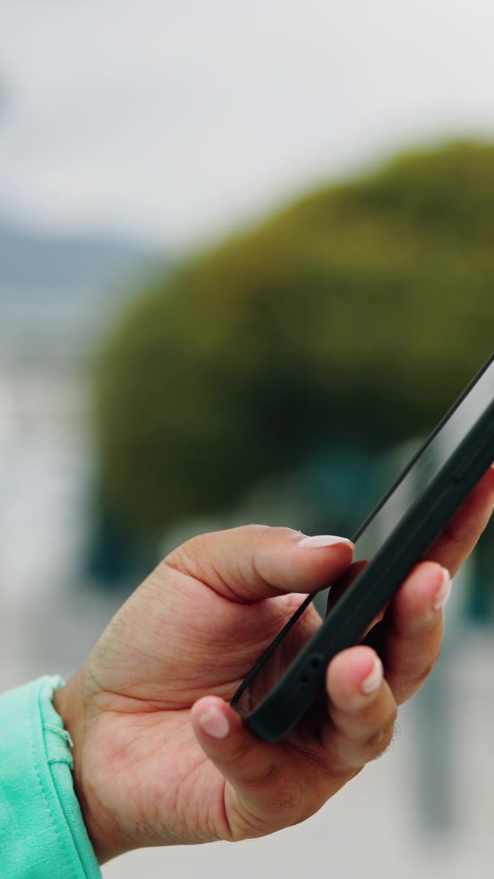 Primo piano di una persona che usa uno smartphone all'aperto