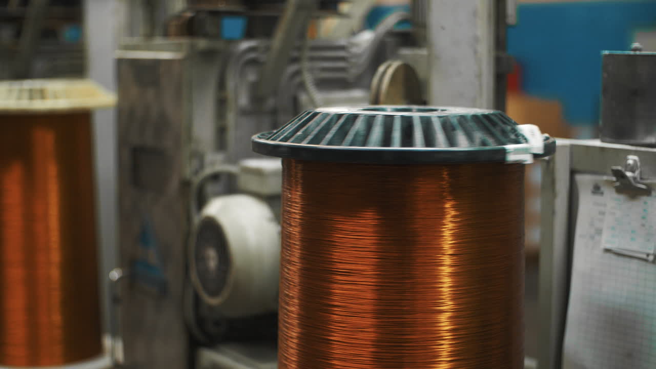 Automatic equipment rolling copper cable on reel at factory. Bronze wire cable