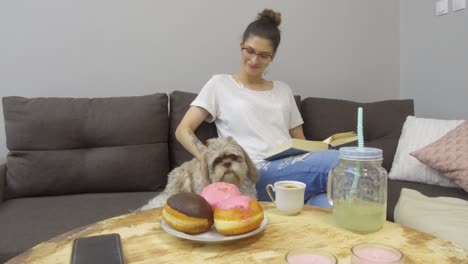 una mujer joven con un lindo perro en casa.