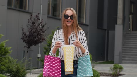 chica con bolsas de compras coloridas, regocijándose de los descuentos en la tienda de moda, disfrutando de las compras en el centro comercial
