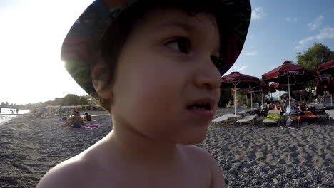 wide footage of a boy playing ay the beach kalamata,greece