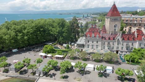 drone flying towards beautiful castle hotel and tilting down to outdoor café and swimming pool