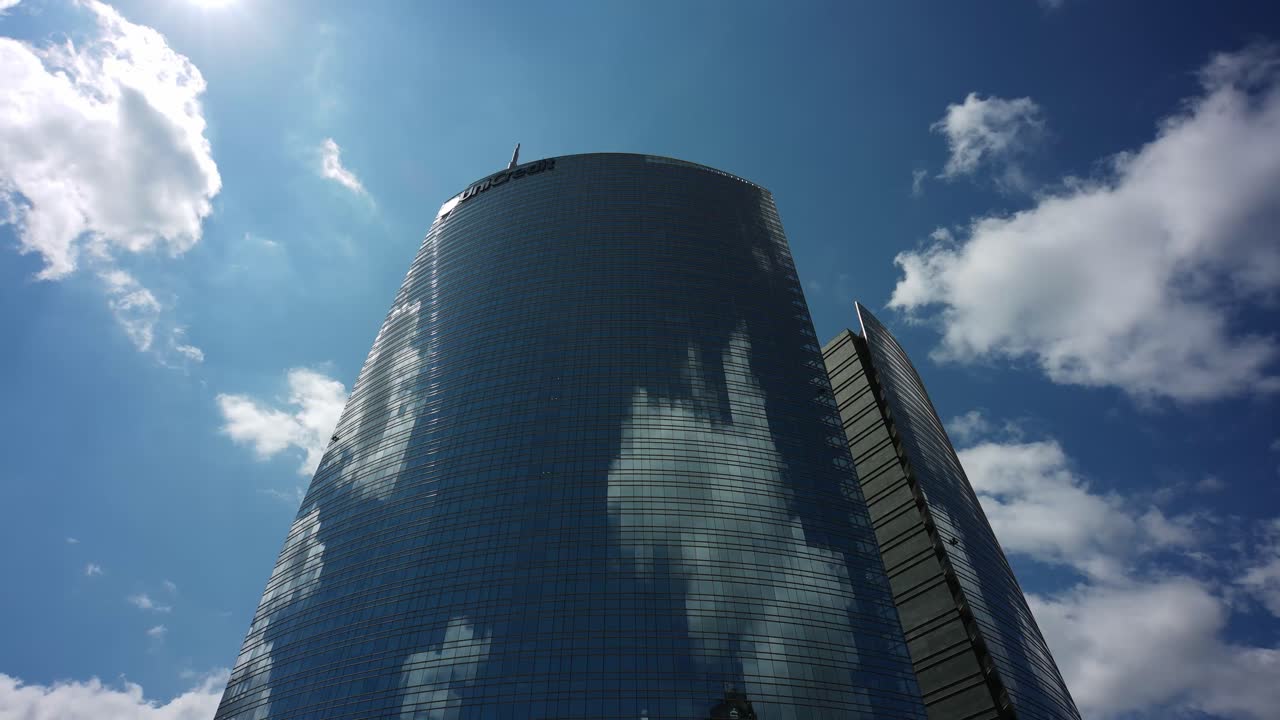 nubes del cielo que se reflejan en la torre unicredit de milán, vista de lapso de tiempo