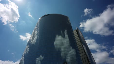 nubes del cielo que se reflejan en la torre unicredit de milán, vista de lapso de tiempo