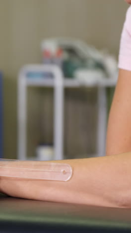 male therapist measuring female patient hand with goniometer