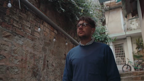 man walking outdoors along narrow street in old town