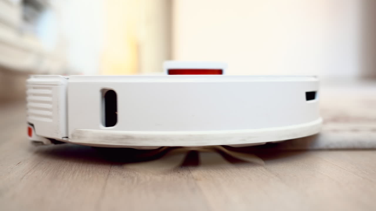 White robot vacuum cleaning the carpet