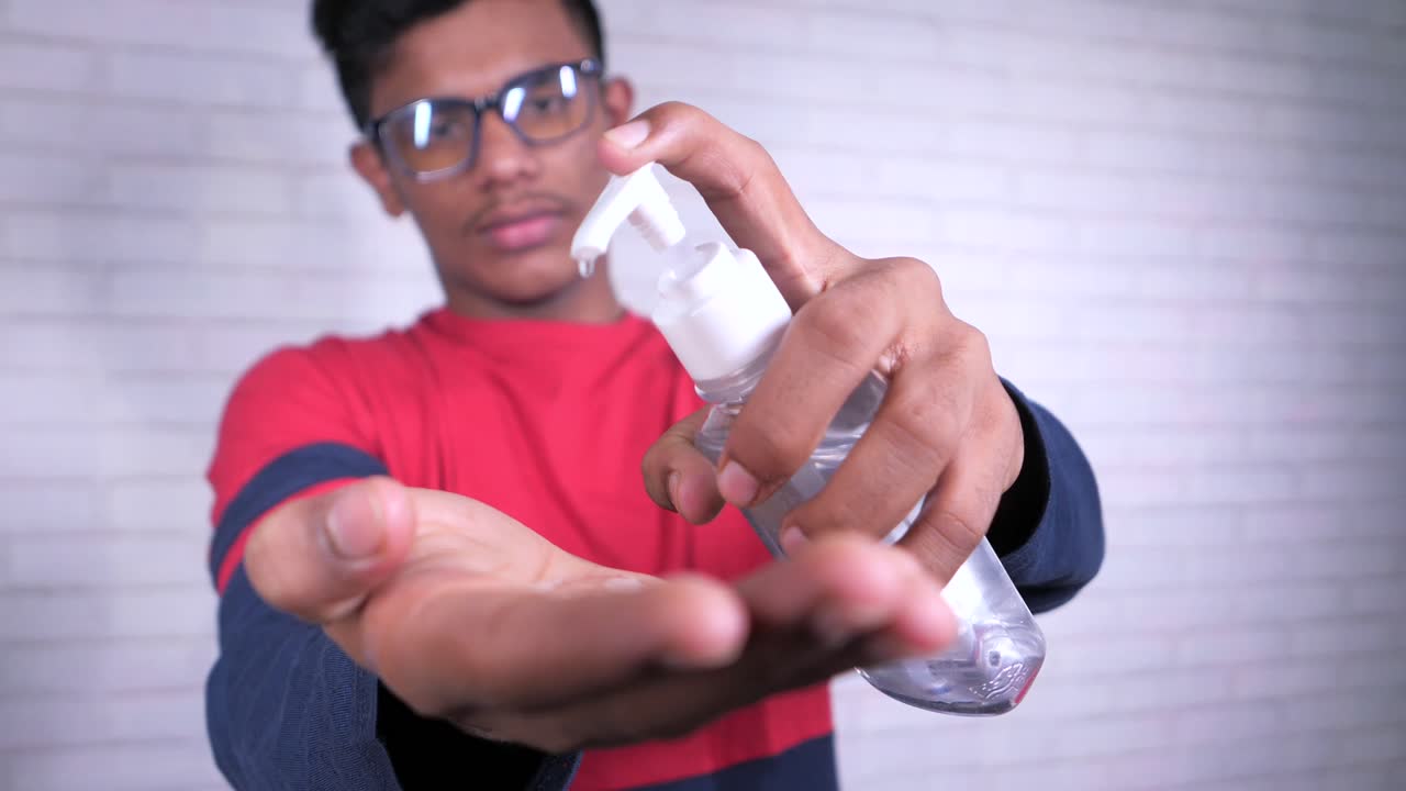 joven aplicando desinfectante para las manos