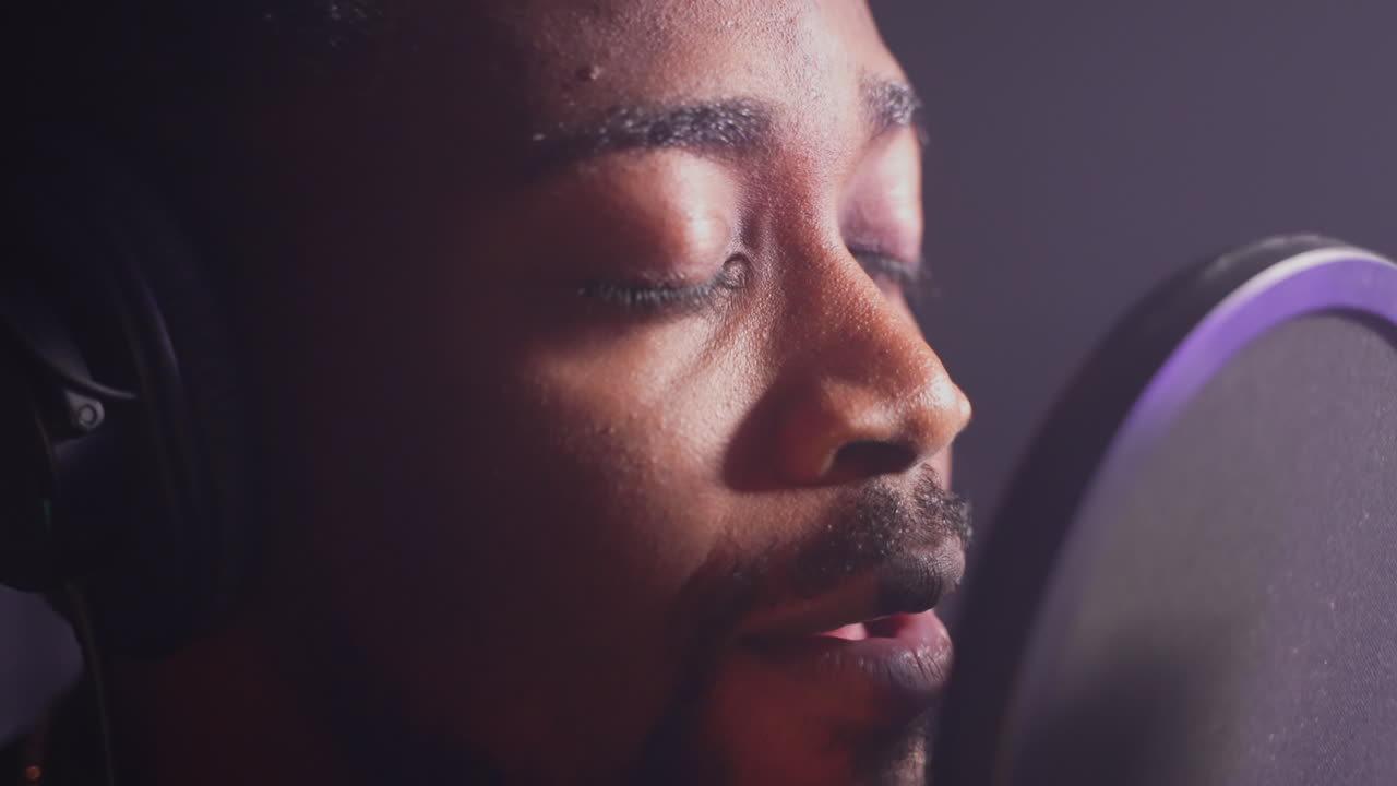 녹음 스튜디오 에서 마이크 로 노래 하는 남자