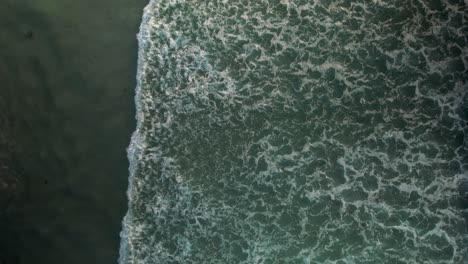 ocean splashing on the shoreline with foamy waves