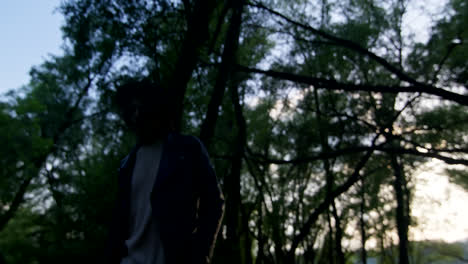 man walking in the forest at sunset