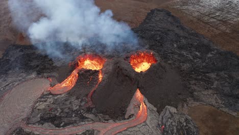 volcano crater eruption with flowing lava and smoke - fagradalsfjall volcano eruption in reykjanes peninsula, south iceland - aerial orbit