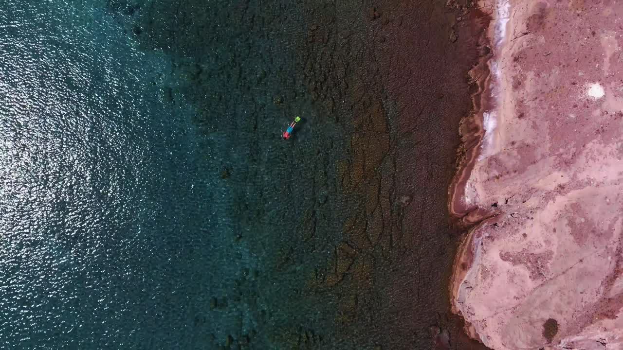 푸른 바다에서 혼자 스노클링하는 남자의 드론 샷