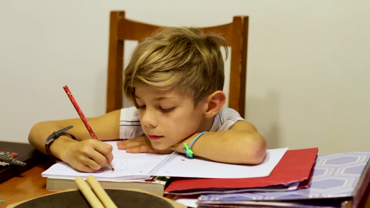 tiro de carro de niño haciendo la tarea en la mesa de la cocina