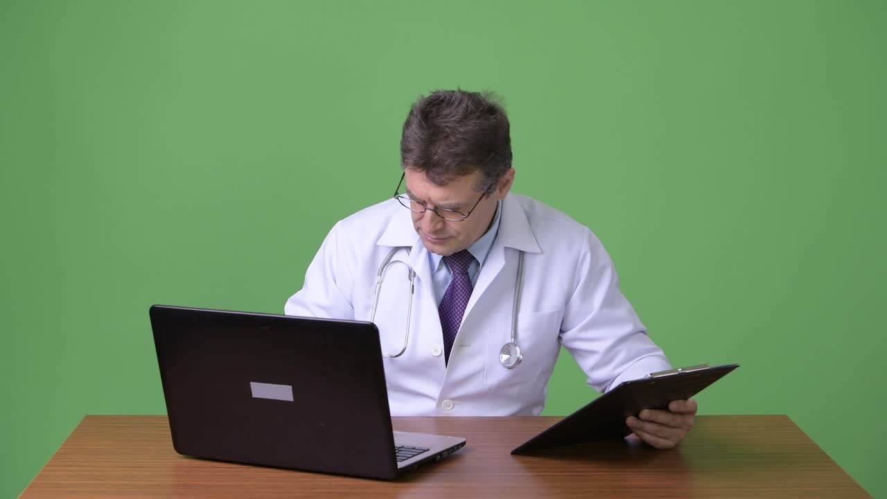 hombre maduro y guapo médico contra fondo verde