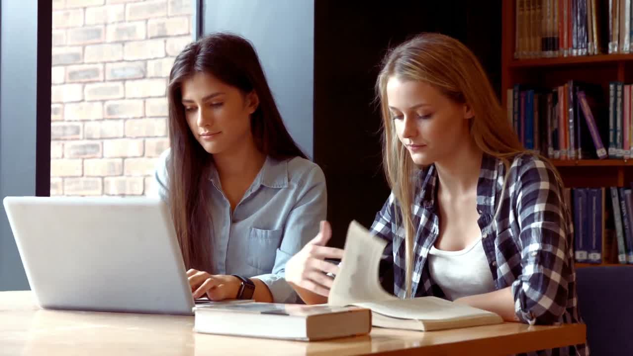 Two students working on a laptop