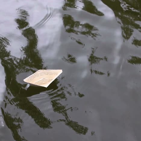 active leisure for children. boy play in paper ship in water puddel