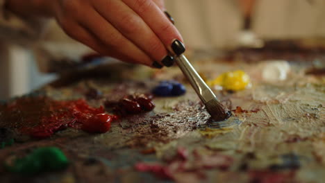 Unrecognizable-woman-taking-paints-on-palette.-Artist-having-brush-in-hand.
