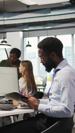 vertical video admin in tech startup office using pc, compiling software patches to fix bugs