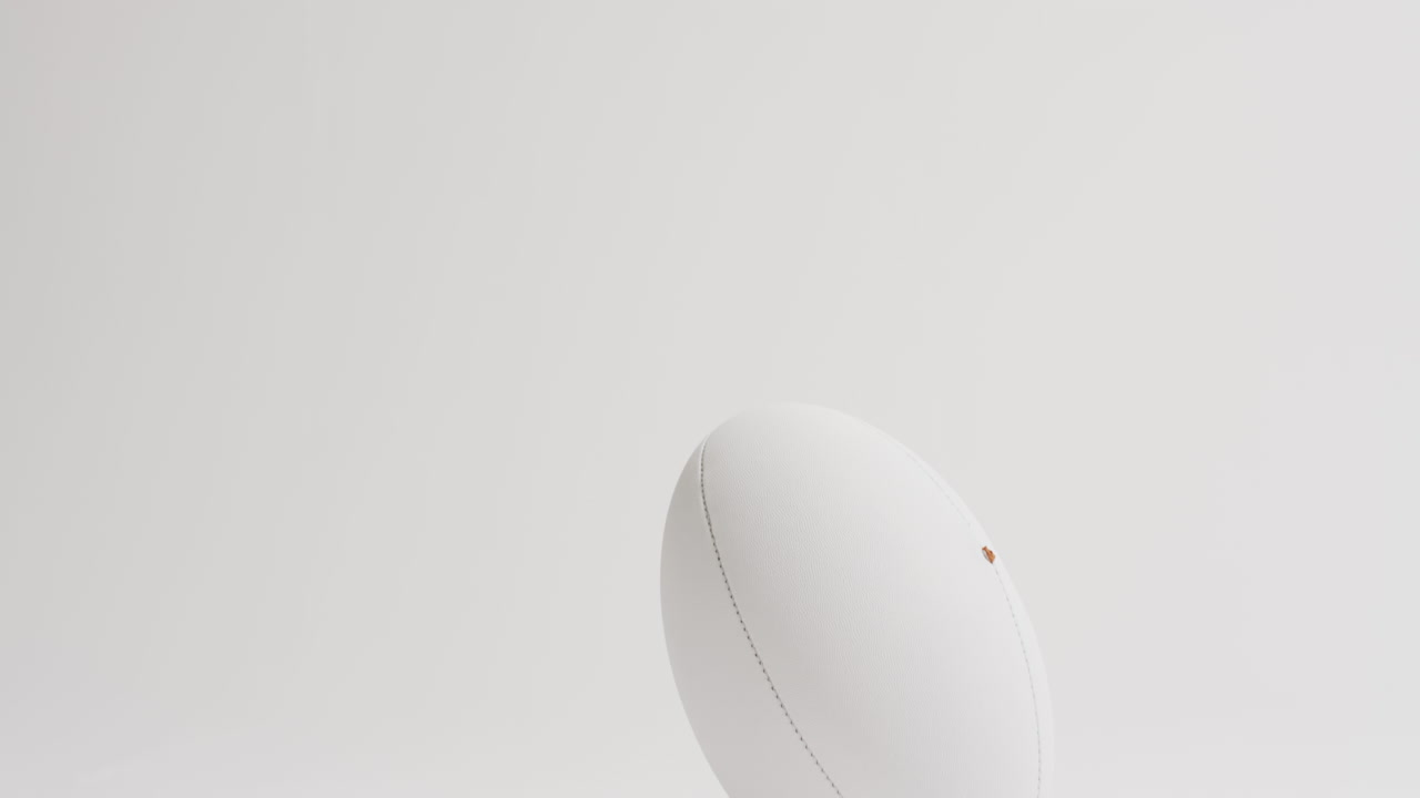 белый мяч для регби на белом фоне с копировальным пространством, замедленное движение