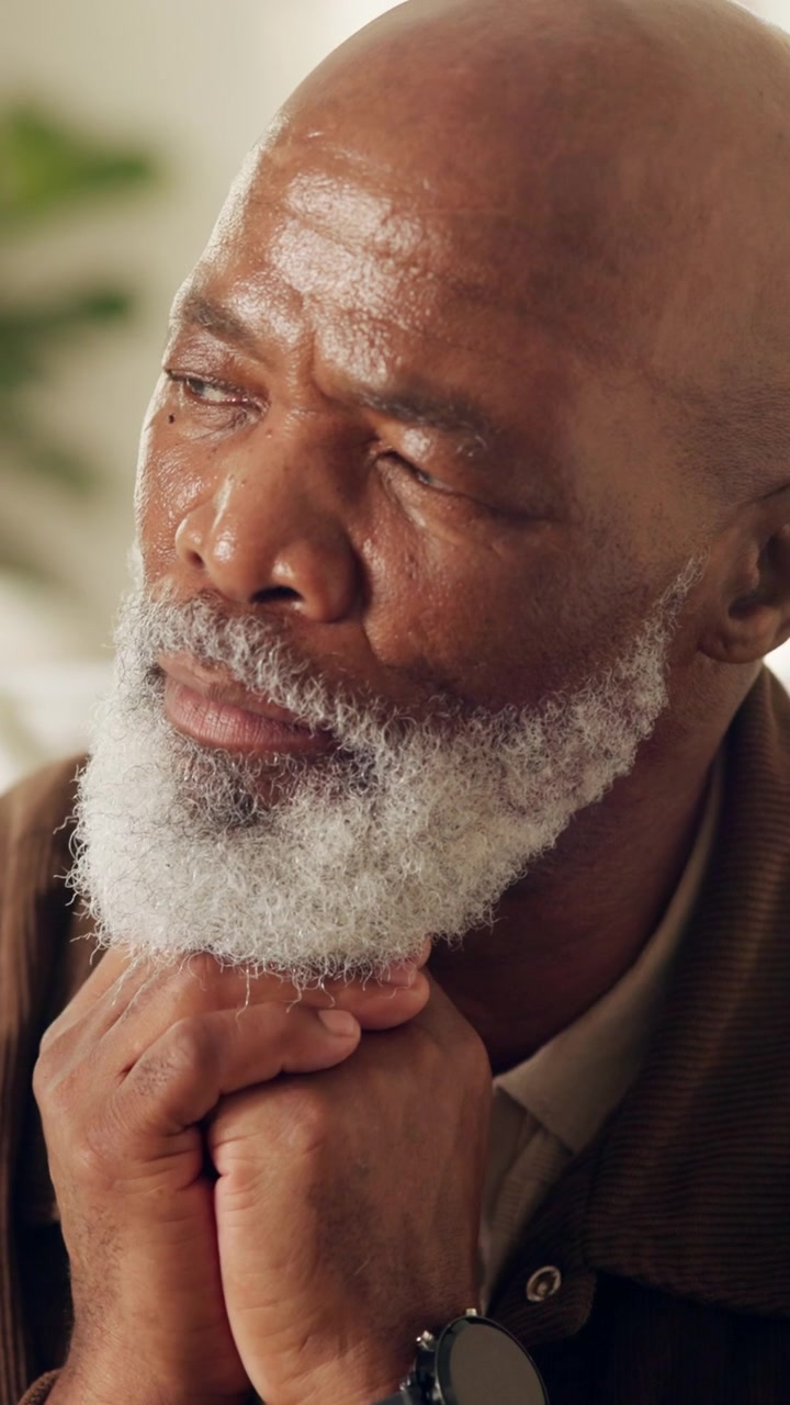 Thoughtful Senior Man Resting Chin on Clasped Hands