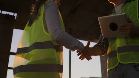 Architektin-Und-Bauarbeiterin-Geben-Sich-Die-Hand.-Kopierraum-Mit-Niedriger-Ansicht