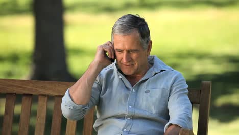 Happy-old-man-talking-on-the-phone-on-a-bench