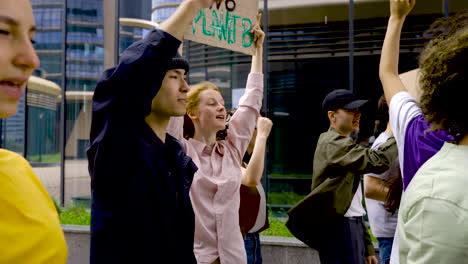 young man with black hat next to red haired woman with board on protest