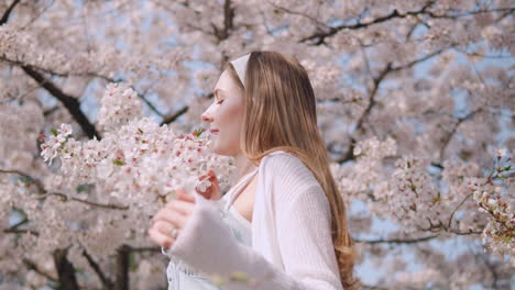 Kaukasische-Frau-Riecht-Den-Frischen-Duft-Der-Kirschblüten-Im-Yangjae-Wald-In-Seocho,-Seoul,-Südkorea