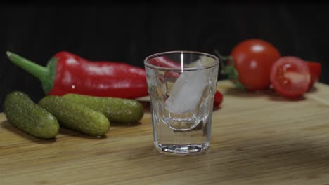 man puts a glass then fills it with vodka and picks up a glass