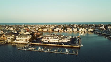 drone shot circling a restaurant sitting harborfront in stone harbor, new jersey