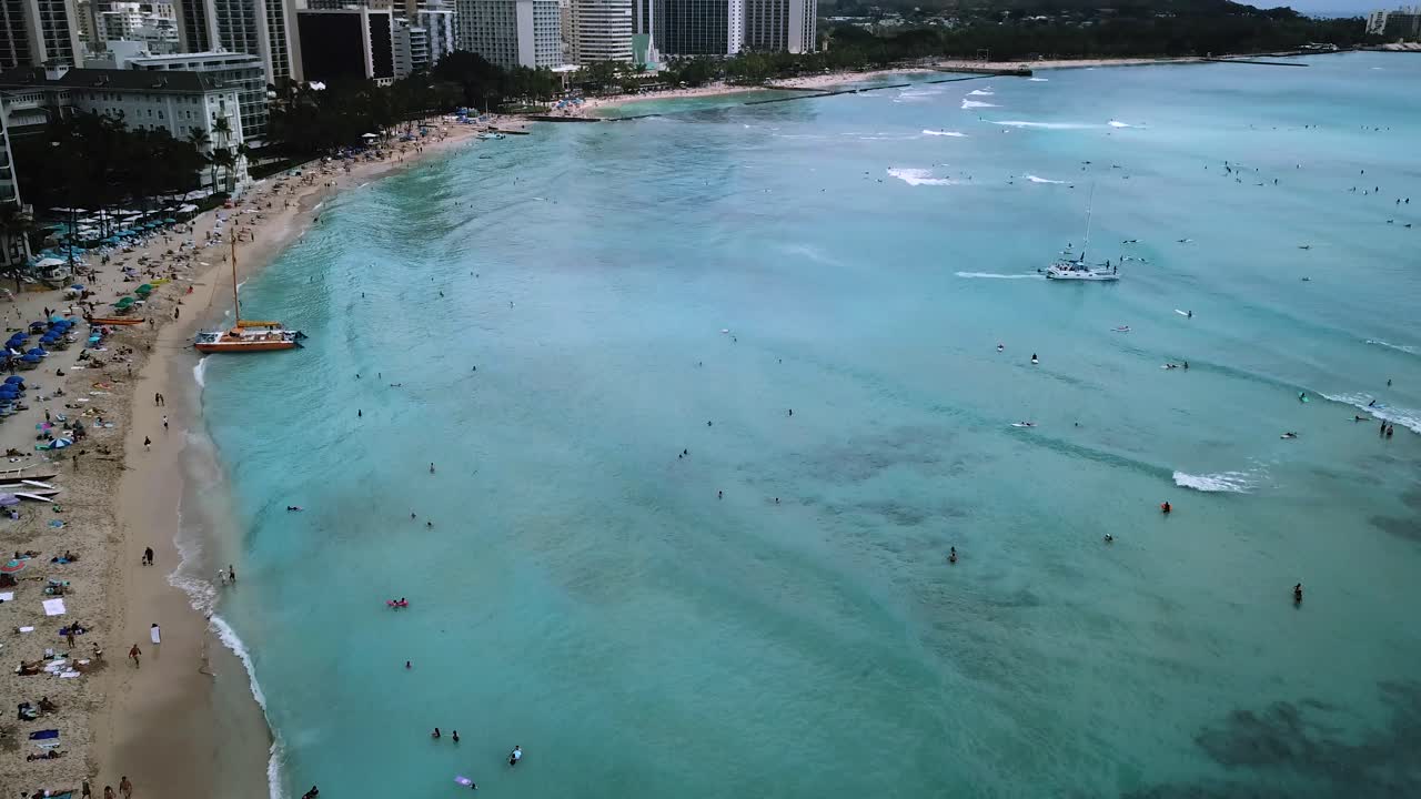 Spiaggia di Waikiki nel centro di Honolulu, Oahu, Hawaii. Ripresa aerea con drone in tilt-up.