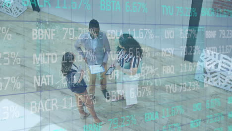 animation of trading board over high angle view of diverse coworkers discussing reports