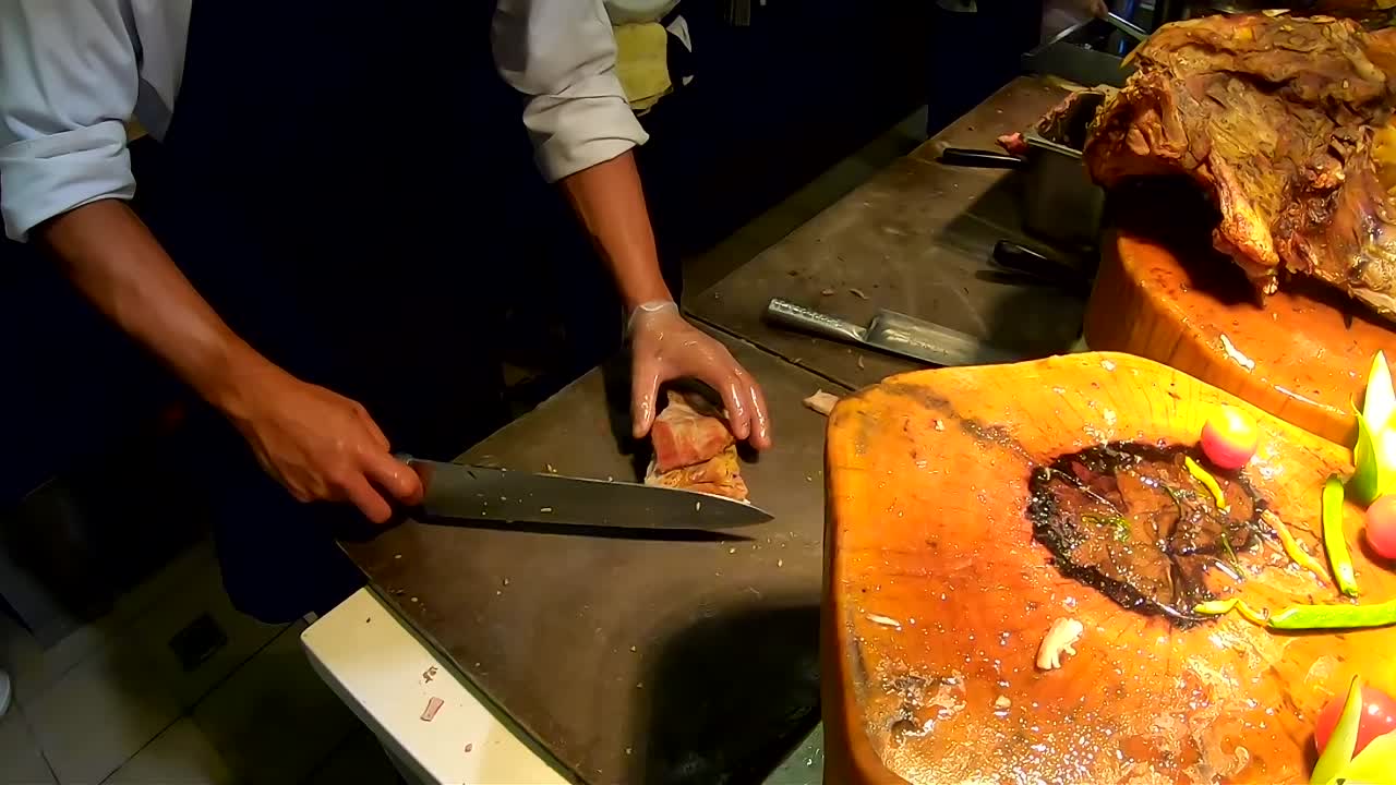 chopping a part of Filipino cuisine Lechon Kawali or roasted deep fried pork meat