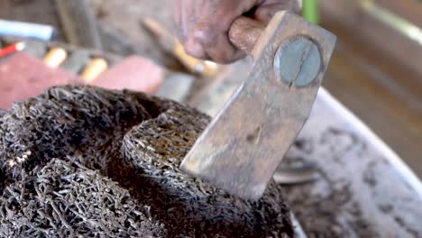 A-close-up-of-a-woodworker's-mallet-being-used-on-a-sculpture-carved-from-a-tree-fern,-extreme-close-up-of-woodcarving-action