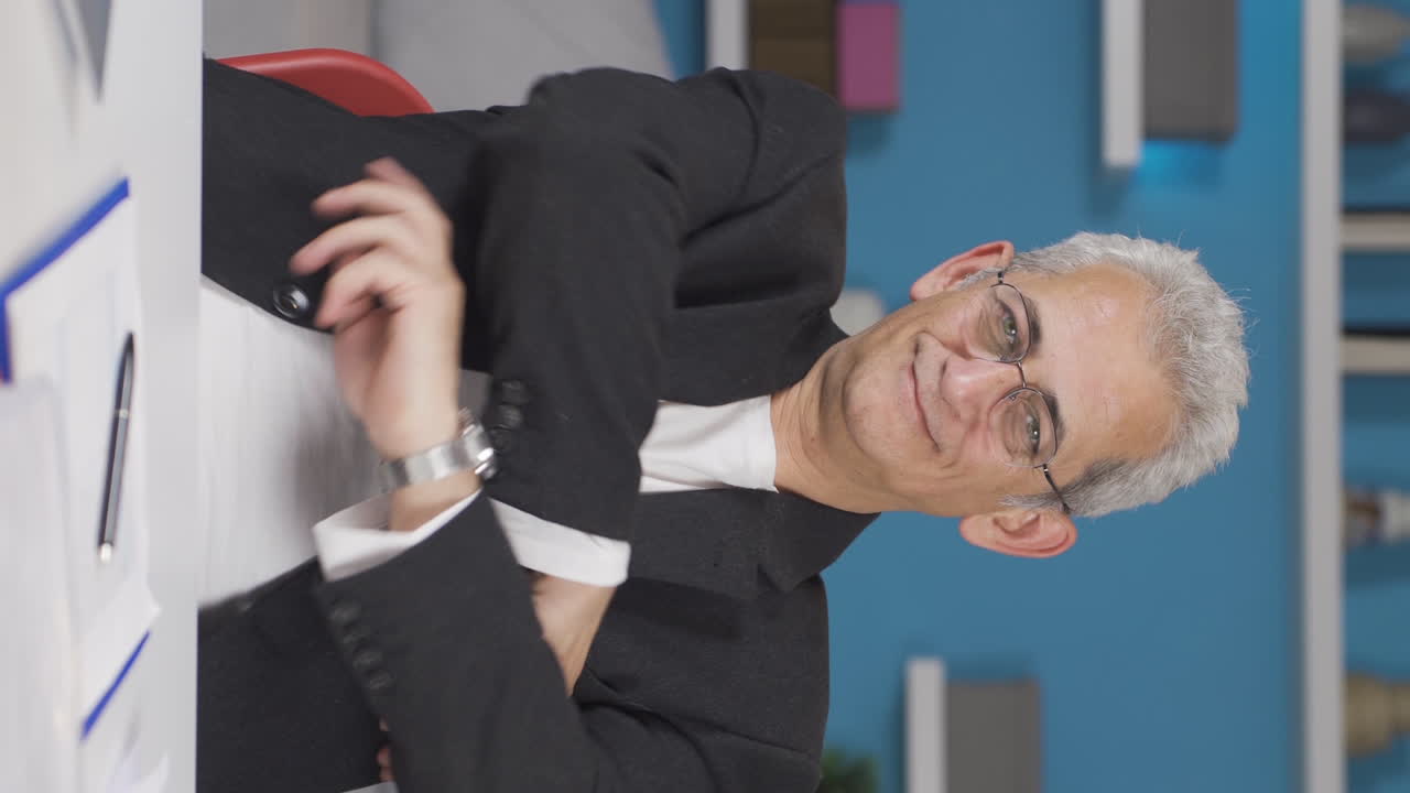 홈 오피스 근로자의 수직 비디오 남자가 카메라에 신뢰 표시를합니다.