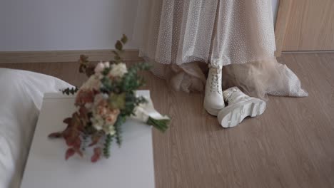 bridal attire: wedding dress, white boots, and bouquet