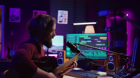 Artist-with-condenser-microphone-composing-a-song-on-guitar