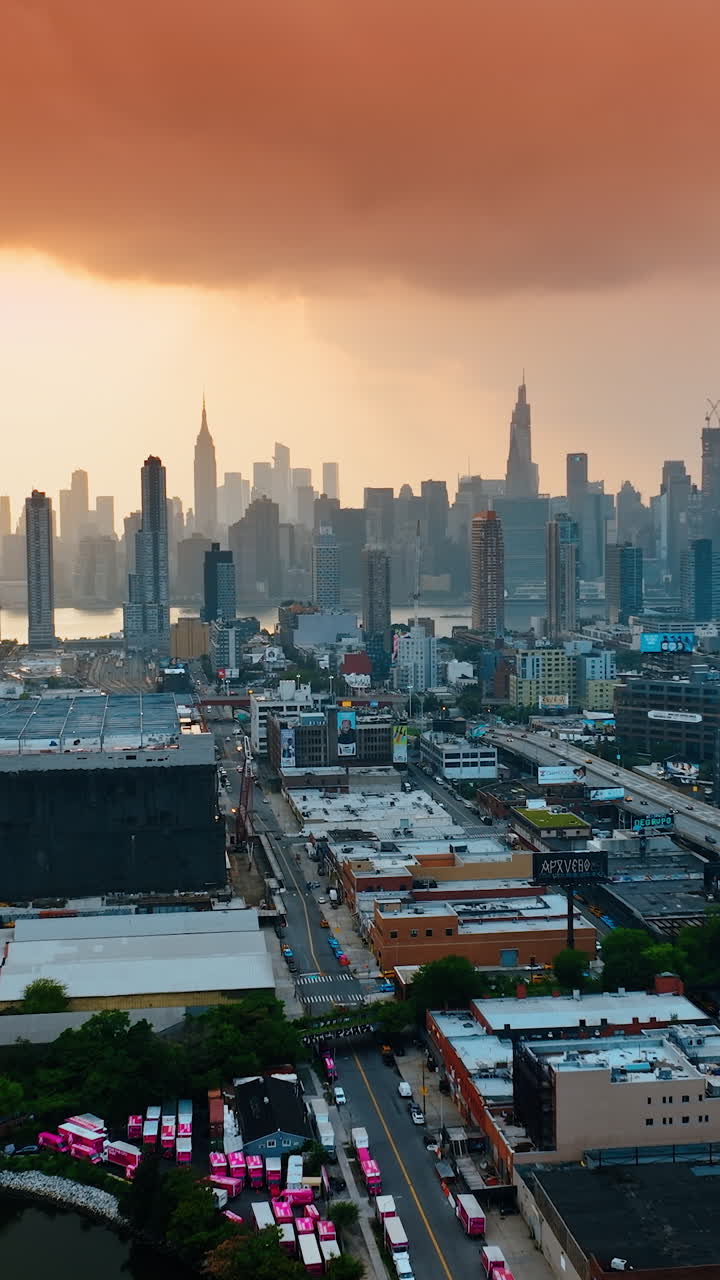 Panorama of New York in the evening. Pink cloudscape covering the sky over the city. Top view. Vertical video