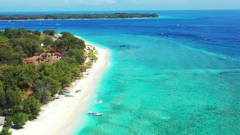 hanimaadhoo island, maldives - beautiful scenery of lush green island with boats docked on the sandy shore surrounded by crystal clear sea - aerial shot