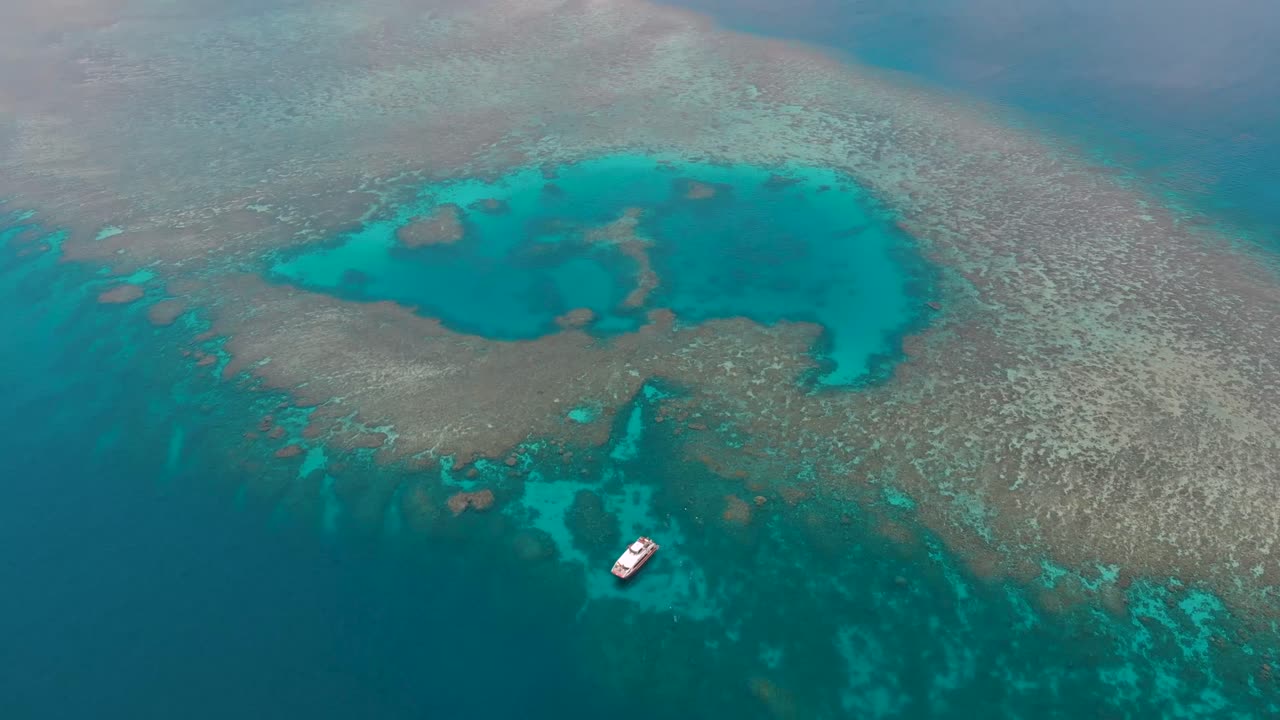 Large Snorkel Tour Boat on Coral Reef. 4K Drone (Fly foward, pan down). Shot on the Great Barrier Reef, Australia.