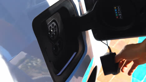 Woman-charging-electric-car-at-charging-station-4k