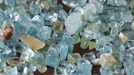 a gemologist sorting through a parcel of aquamarine rough, close up