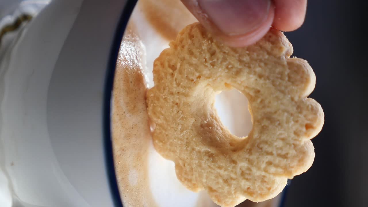 Cookie dipping into coffee