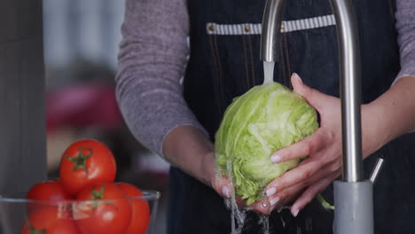 Women's-hands-hold-cabbage-under-a-stream-of-water