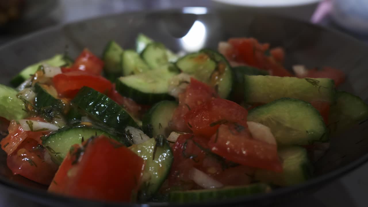 Fresh vegetables are tossed in a glossy dressing, creating a vibrant and appealing salad. Close-up view highlights the colorful ingredients
