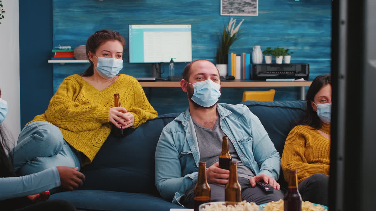 Multiethnic friends looking at television laughing