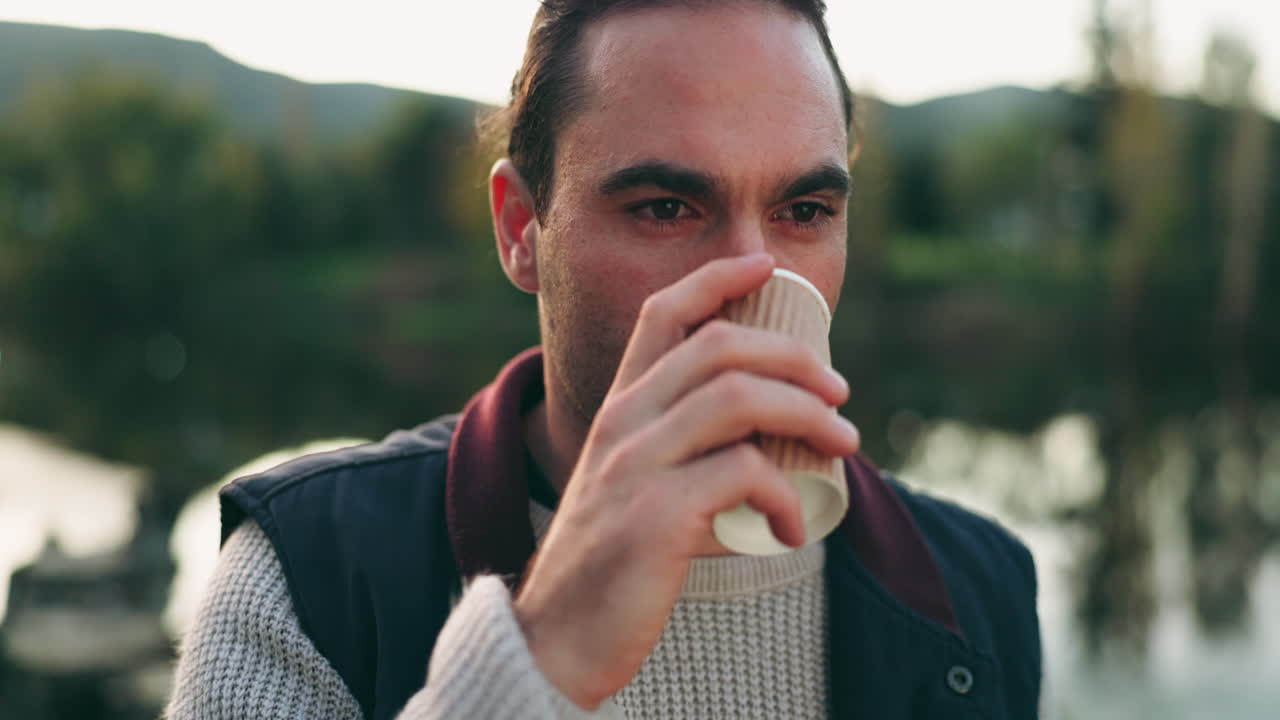Natura, tazza di caffè e giovane uomo al lago