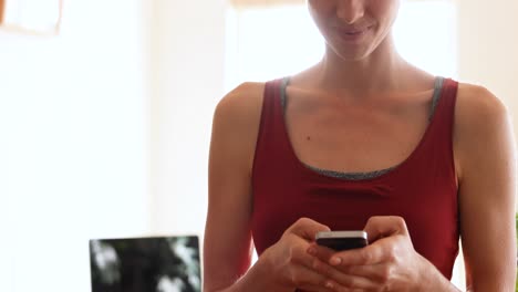 mujer caucásica usando su teléfono en casa