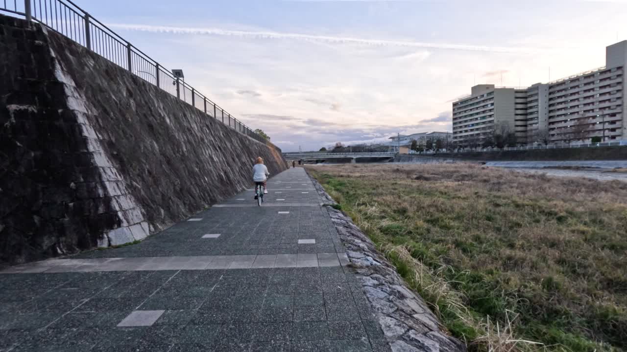 강과 건물 에서 자전거를 타는 사람